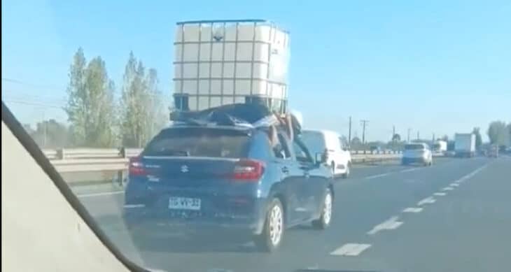 Captan peligrosa maniobra: pasajeros sostienen enorme estanque desde las ventanas en plena carretera